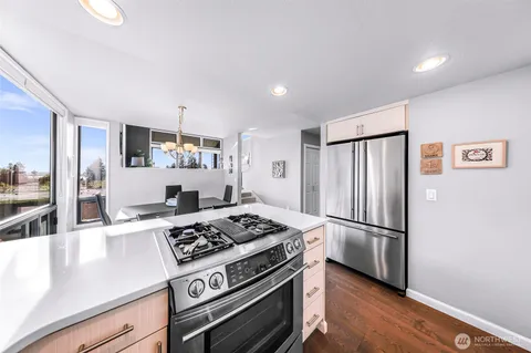 a kitchen with a stove a sink and chairs