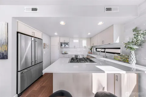 a kitchen with stainless steel appliances kitchen island granite countertop a kitchen island a stove a table and chairs