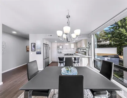 a dining room with furniture a chandelier and wooden floor