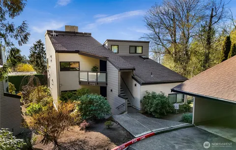 a view of a house with a yard and potted plants