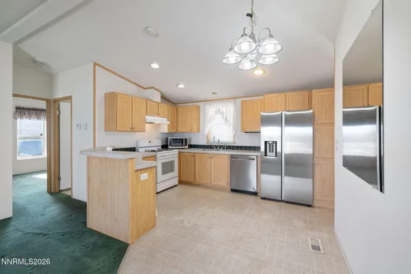 a large kitchen with stainless steel appliances granite countertop a refrigerator and a stove top oven