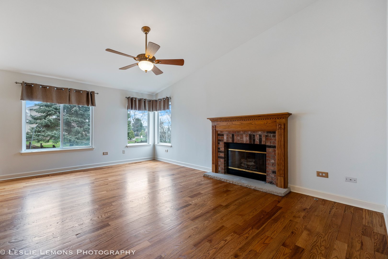 1940 Baldwin Way Bolingbrook, IL 60490 - Photo 10 of 28 an empty room with windows fireplace and a ceiling fan