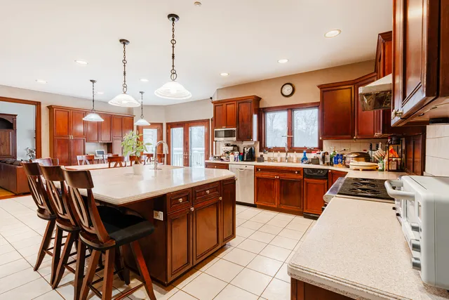 a kitchen with stainless steel appliances granite countertop a stove a sink dishwasher and a refrigerator with wooden floor