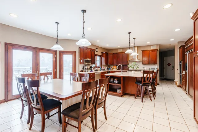 a dining room with stainless steel appliances kitchen island granite countertop a dining table and chairs