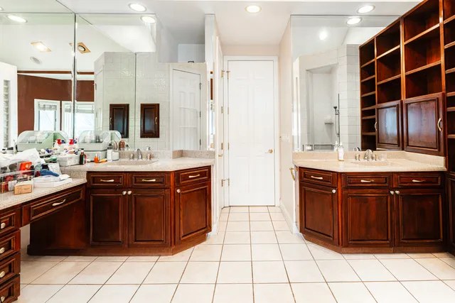 a bathroom with a sink vanity granite tub shower and a mirror