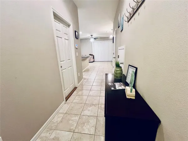 a hallway with white cabinets and wooden floor
