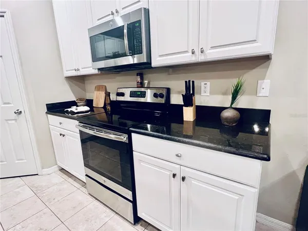 a kitchen with stainless steel appliances granite countertop a sink a stove and microwave