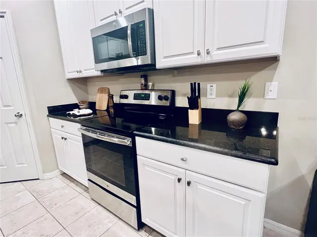 a kitchen with stainless steel appliances granite countertop a sink a stove and microwave