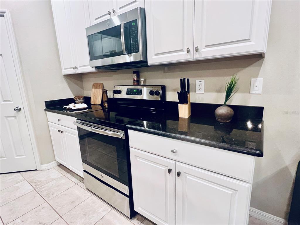 7007 Towne Lake Road Riverview, FL 33578 - Photo 4 of 16 a kitchen with stainless steel appliances granite countertop a sink a stove and microwave