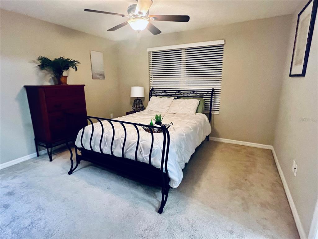7007 Towne Lake Road Riverview, FL 33578 - Photo 6 of 16 a bedroom with a bed lamp and a potted plant