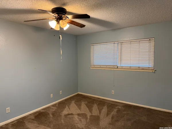 a view of a room with a mirror and a ceiling fan