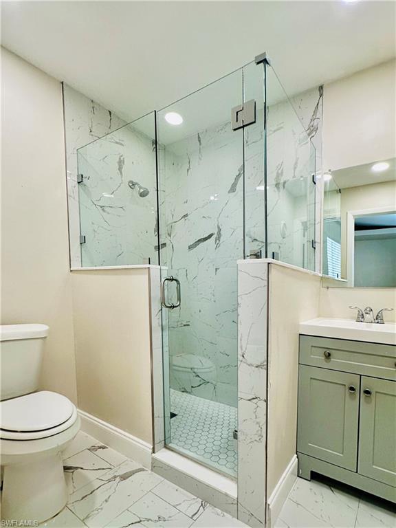 826 Wiggins Pass Road, Unit 310 Naples, FL 34110 - Photo 13 of 18 Bathroom featuring light marble finish floors, a marble finish shower, vanity, and recessed lighting