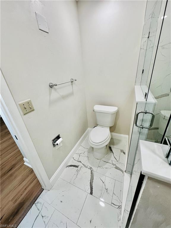 826 Wiggins Pass Road, Unit 310 Naples, FL 34110 - Photo 16 of 18 Full bathroom featuring light marble finish floors, a marble finish shower, and vanity