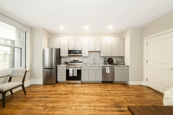 a kitchen with a refrigerator and a stove top oven