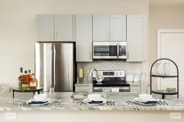 a kitchen with stainless steel appliances granite countertop a stove top oven a sink and a microwave