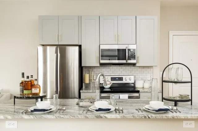 a kitchen with stainless steel appliances granite countertop a stove top oven a sink and a microwave