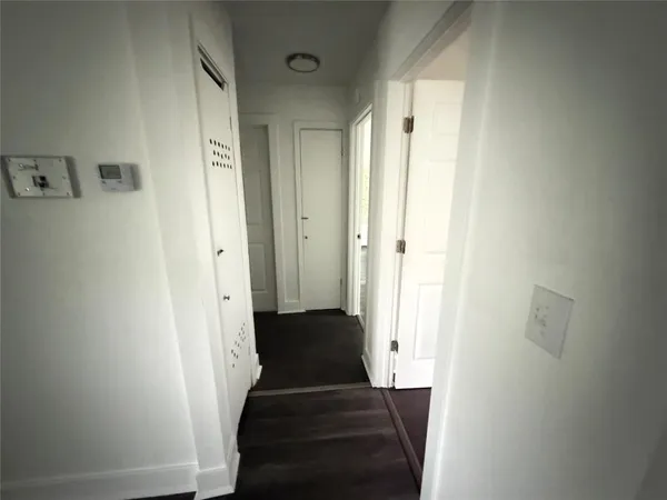 a view of a hallway with a closet and front door