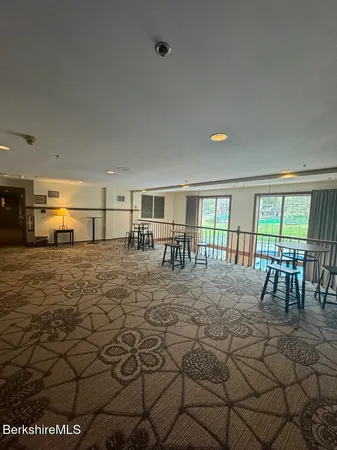 a living room with couches a coffee table and kitchen view with wooden floor
