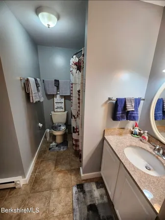 a bathroom with a granite countertop sink toilet and a mirror