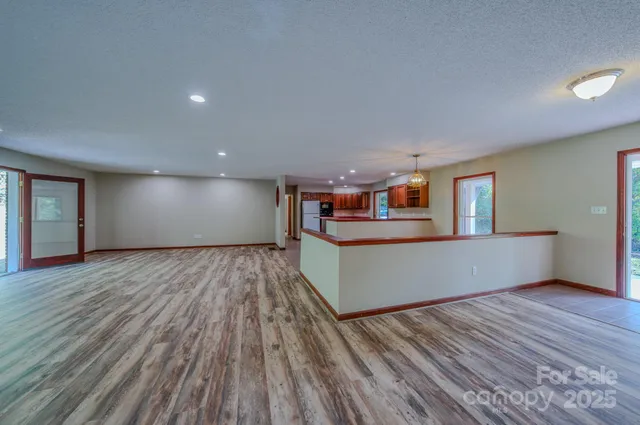 a view of a living room and kitchen with furniture wooden floor and chandelier