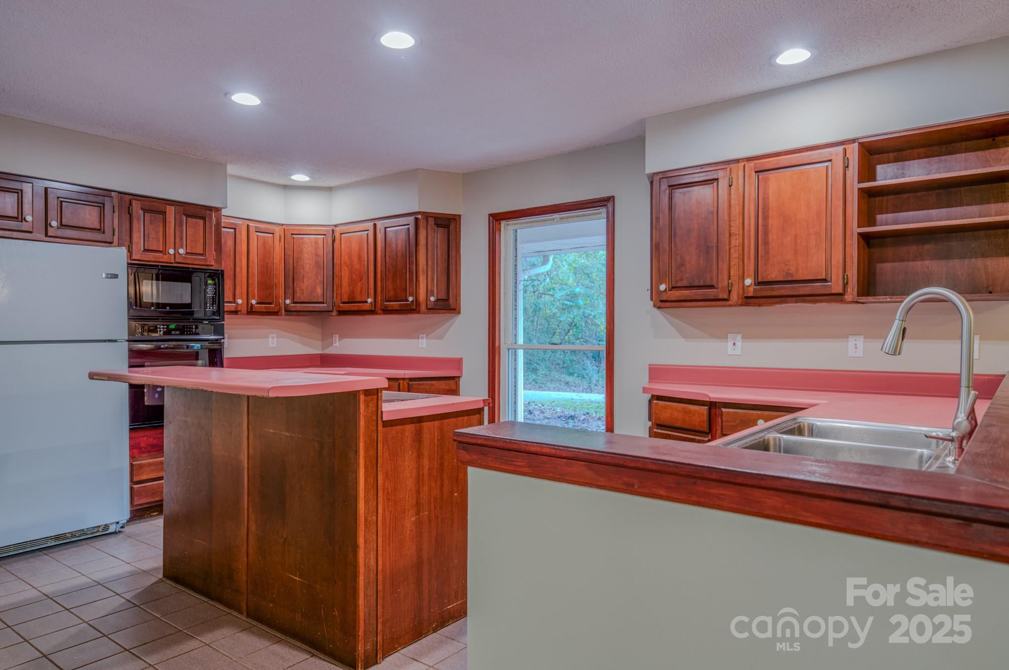 35 Byrd Road Candler, NC 28715 - Photo 23 of 46 a kitchen with stainless steel appliances granite countertop wooden cabinets a refrigerator and a sink