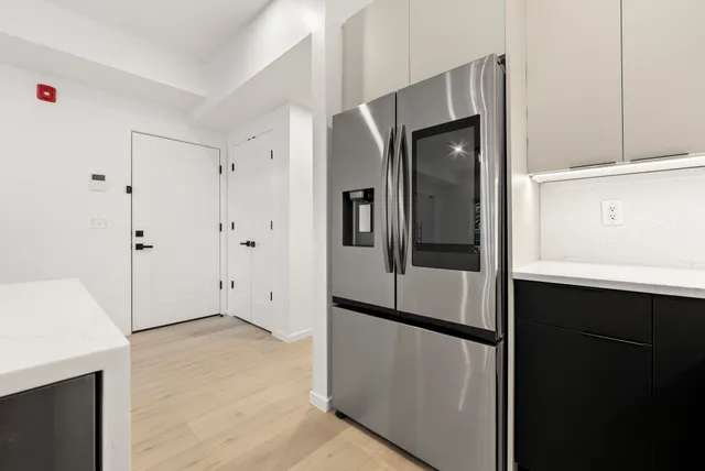 a view of kitchen with a refrigerator cabinets and a wooden floor