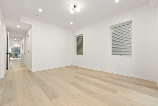 an empty room with wooden floor and a bathroom
