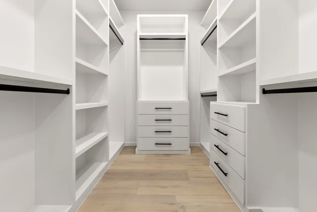 a view of walk in closet with empty racks