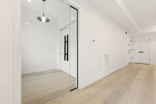 an empty room with cabinet and a chandelier fan
