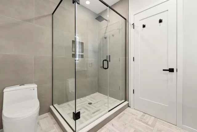 a bathroom with a shower toilet and sink