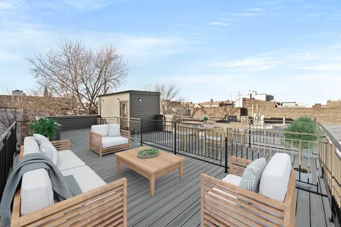 a view of roof deck with couches and wooden floor