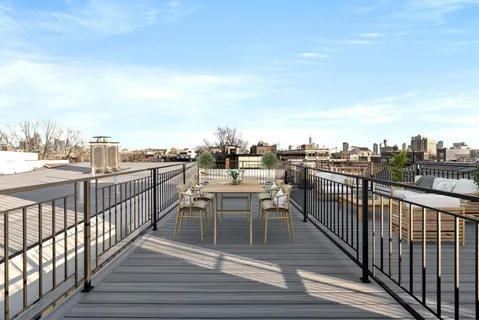 a view of a balcony with wooden floor table and chairs