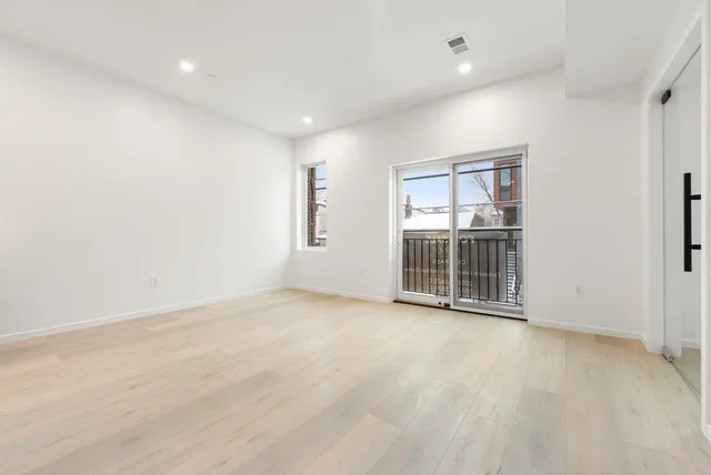 an empty room with entrance and windows
