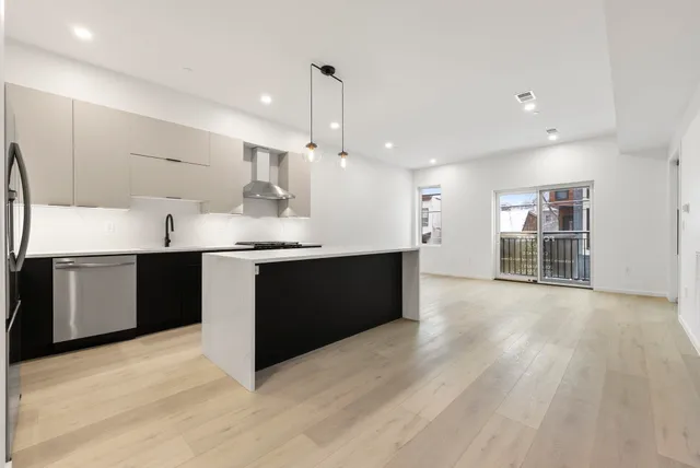 a kitchen with stainless steel appliances granite countertop a sink counter space and wooden floor