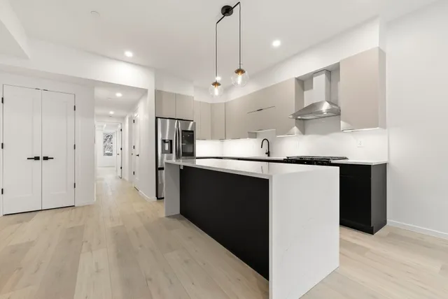 a kitchen with kitchen island a sink stainless steel appliances and a chandelier