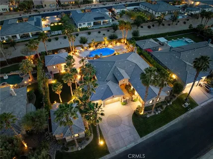 an aerial view of a house with a yard and a large tree