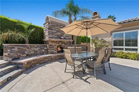a view of a patio with chairs under an umbrella