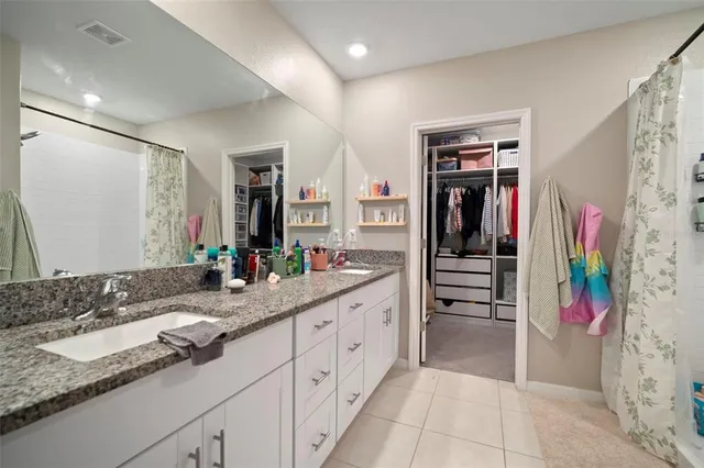 a spacious bathroom with a granite countertop sink and a mirror