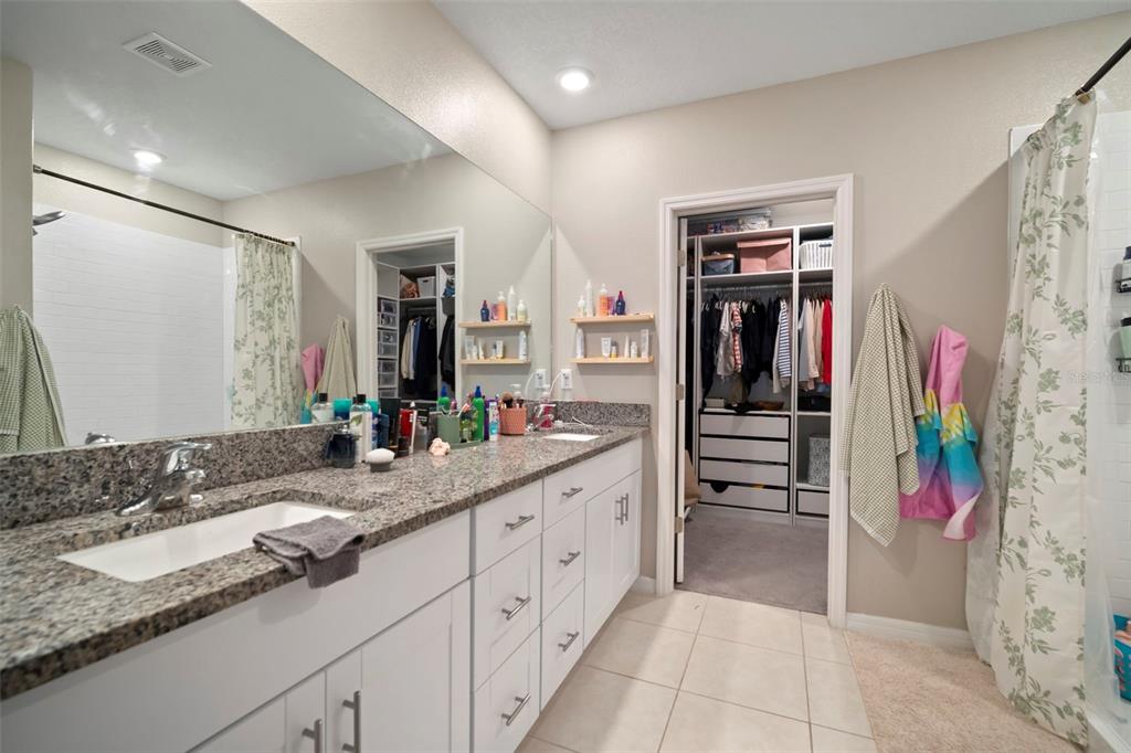 5430 Blue Azure Drive Wimauma, FL 33598 - Photo 28 of 46 a spacious bathroom with a granite countertop sink and a mirror