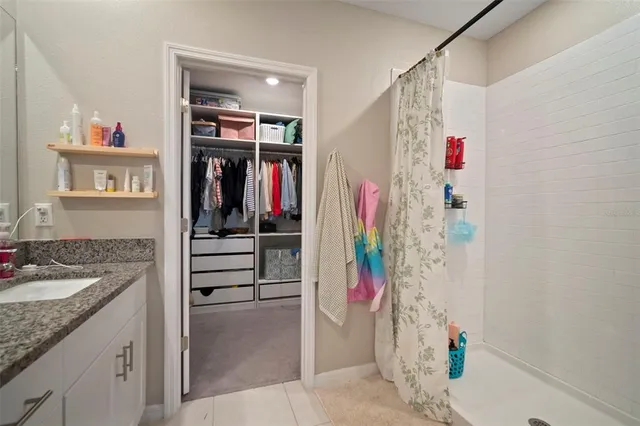 a spacious bathroom with a granite countertop sink mirror and a shower