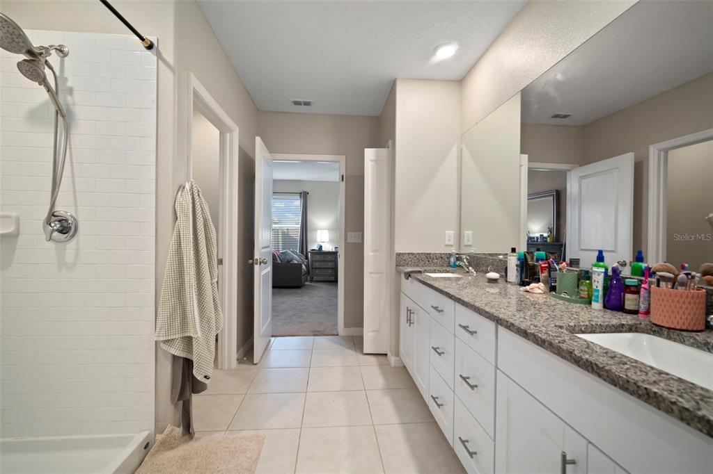 5430 Blue Azure Drive Wimauma, FL 33598 - Photo 30 of 46 a spacious bathroom with a granite countertop sink mirror and a shower