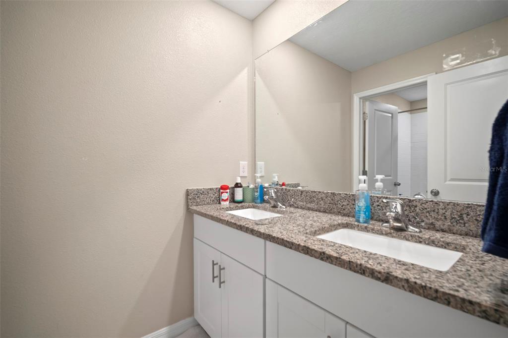 5430 Blue Azure Drive Wimauma, FL 33598 - Photo 39 of 46 a bathroom with a granite countertop sink and a mirror