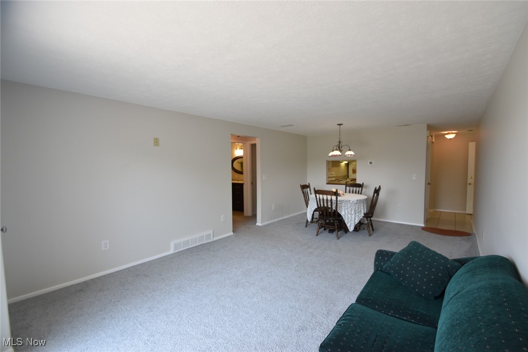 8955 West Ridge Road, Unit D Elyria, OH 44035 - Photo 17 of 33 Carpeted living area featuring a chandelier and baseboards