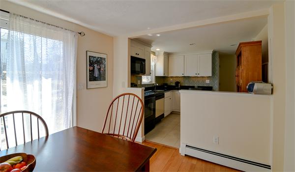 10 Spring Valley Road Natick, MA 01760 - Photo 8 of 17 a kitchen with granite countertop a stove a sink a refrigerator and a dining table with wooden floor