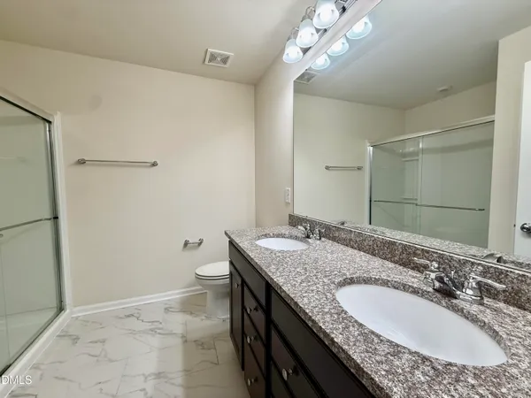 a bathroom with a granite countertop sink a toilet and a mirror