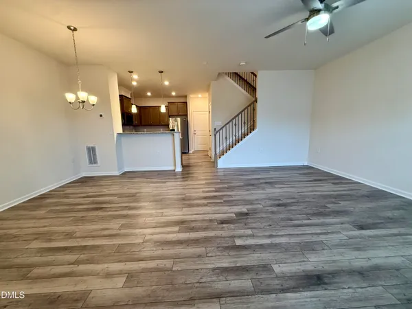a view of a room with wooden floor and ceiling fan