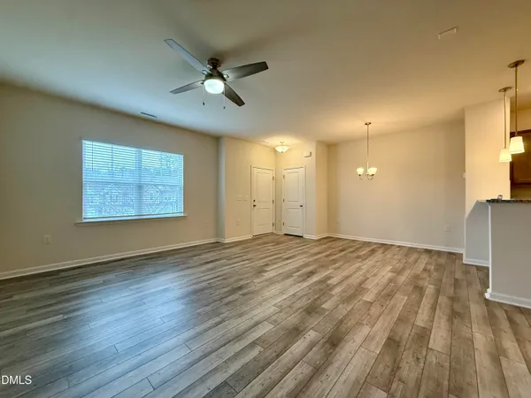 a view of a room with wooden floor and a ceiling fan