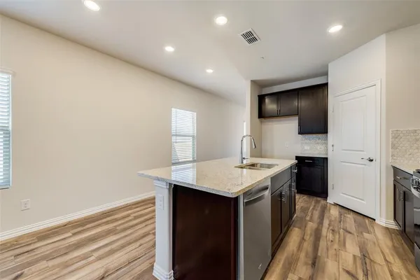 a kitchen with a sink a counter top space stainless steel appliances and cabinets