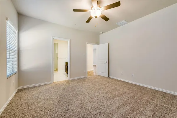 an empty room with closet and a ceiling fan