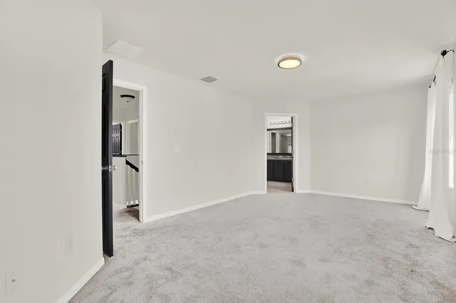 an empty room with closet and windows